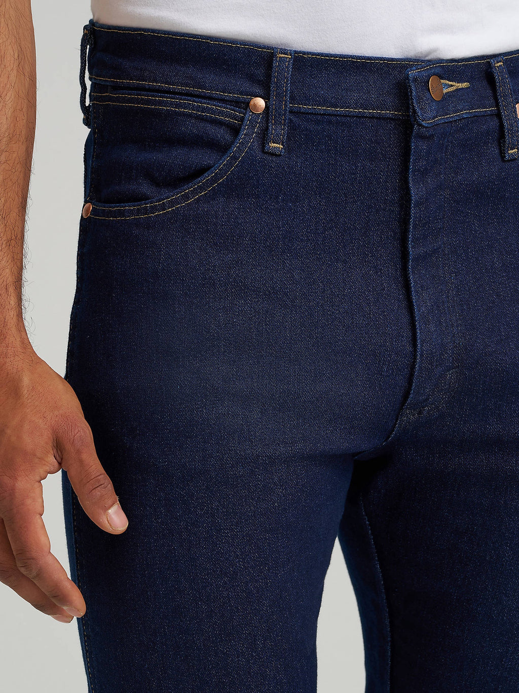 Close-up of the waistband, button and front pocket of Wrangler 13MAFPW Active Flex jeans in Prewashed Indigo.