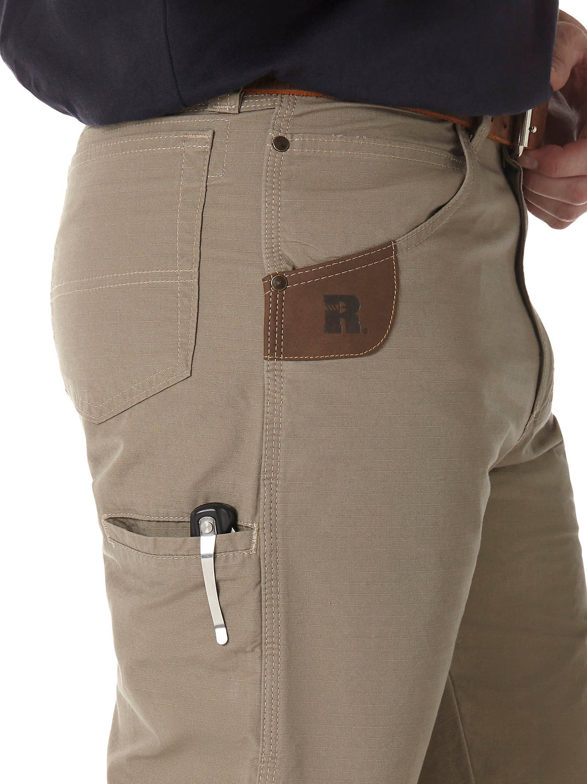 Side utility pocket holding a small device on Wrangler RIGGS Technician pants in Dark Khaki.