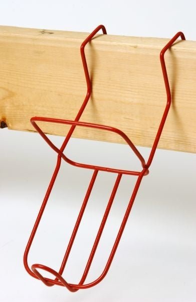 A red metal wire holder designed to hang on a board for securing a 2-quart calf nursing bottle.