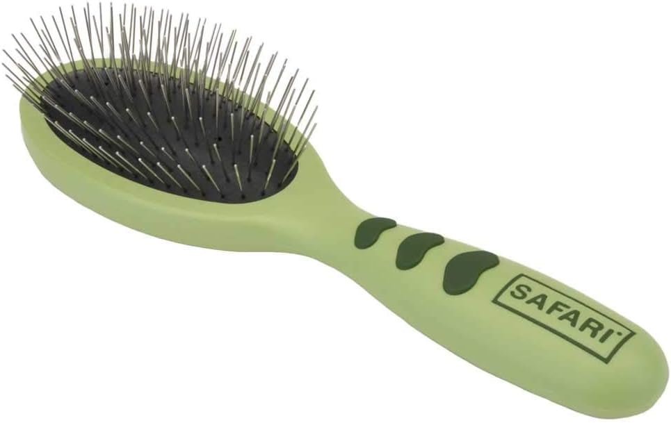 A small green pet grooming brush with metal pins and an ergonomic handle.