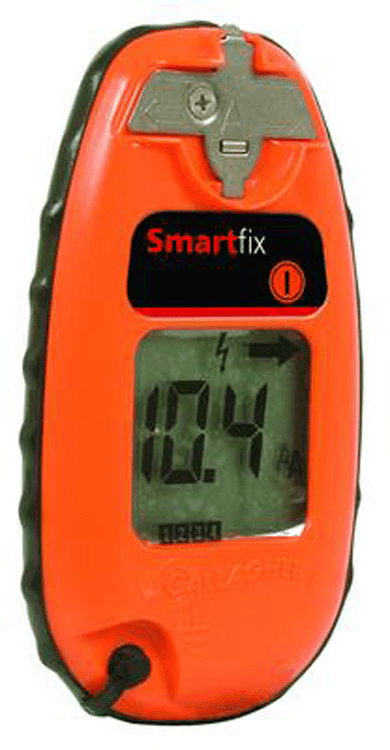 An orange Gallagher Smartfix fence tester with a digital display showing a voltage reading.