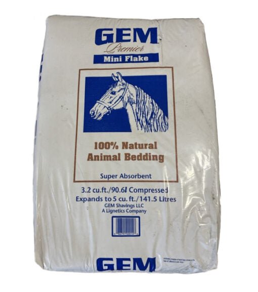 A compressed bag of Gem Premier mini flake animal bedding featuring a horse illustration.