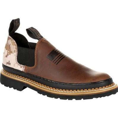 A brown leather slip-on work shoe with a desert camo heel and an embossed American flag.