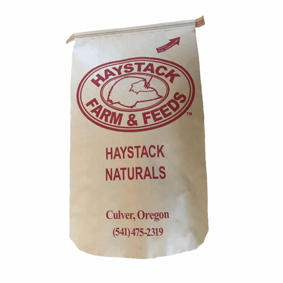 A paper bag of Haystack Naturals goat feed with the company logo and contact information.