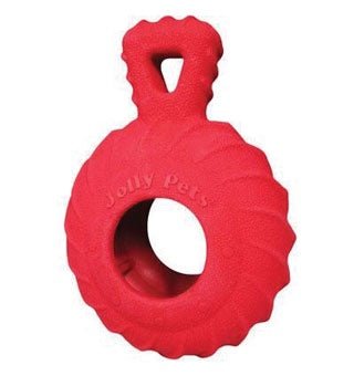 A red, circular rubber dog toy with a textured tread pattern and an integrated handle.
