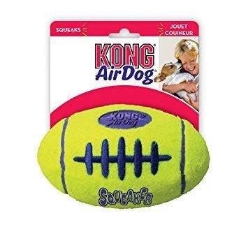 A yellow Kong AirDog football toy with blue stitching and a squeaker inside its packaging.