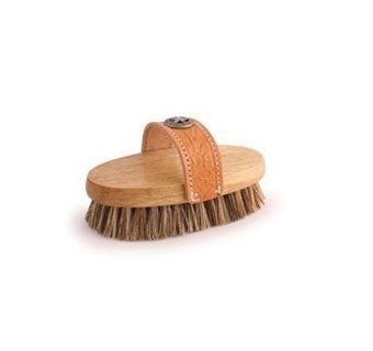 A wooden grooming brush with stiff union fibers and a hand-tooled leather strap.