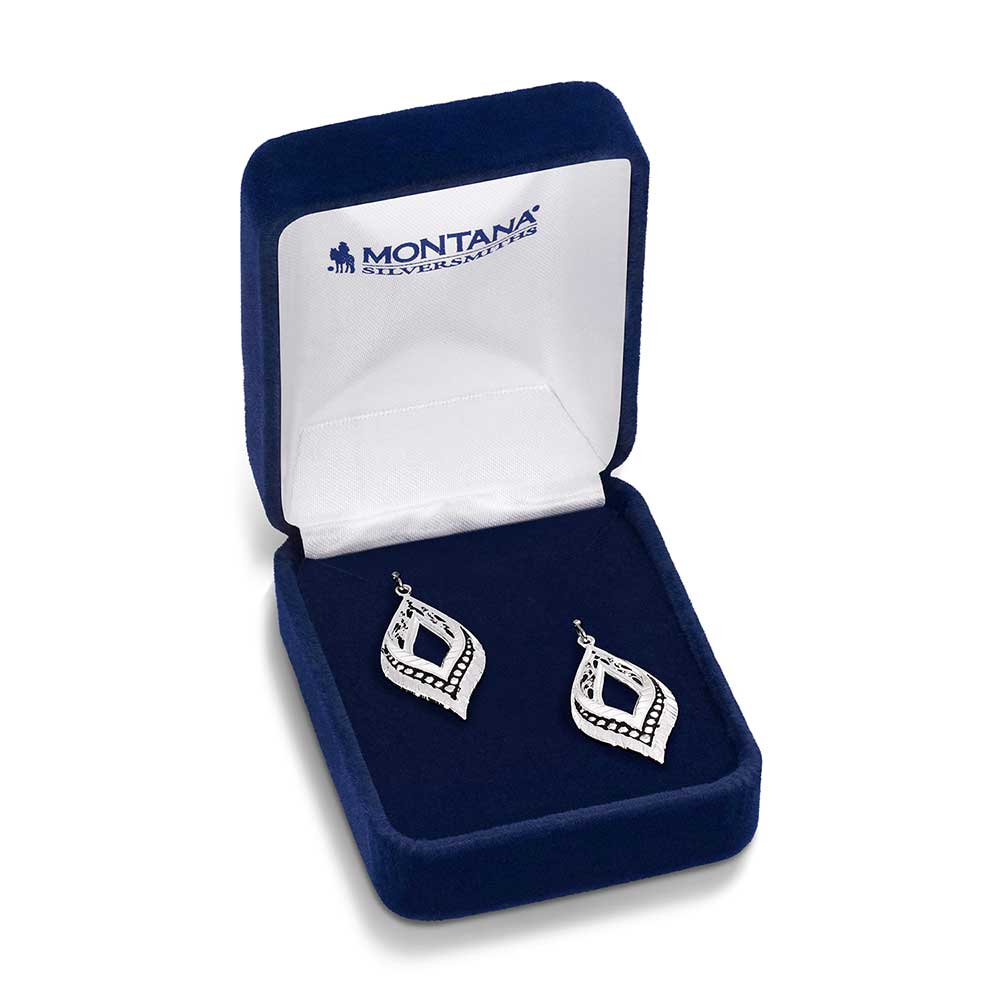 A pair of silver-toned, teardrop-shaped earrings with feather and filigree details in a blue box.