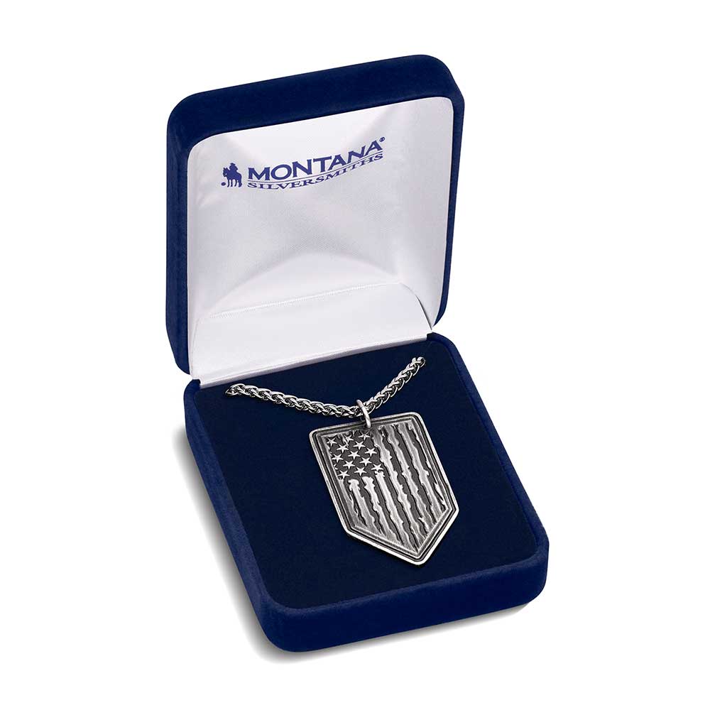 A gunmetal and silver-toned arrow-shaped pendant featuring a tattered American flag design.