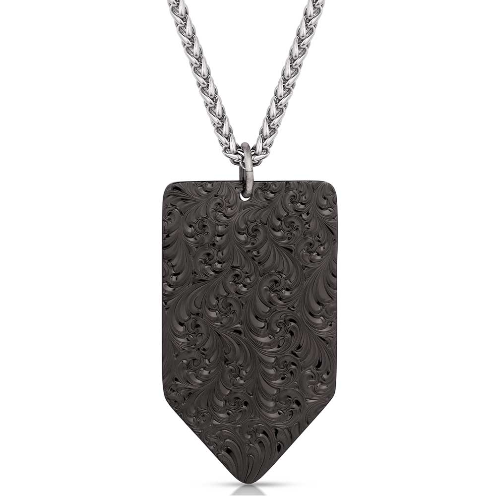 A gunmetal arrow-shaped pendant with an intricate scrollwork pattern hangs from a silver chain.