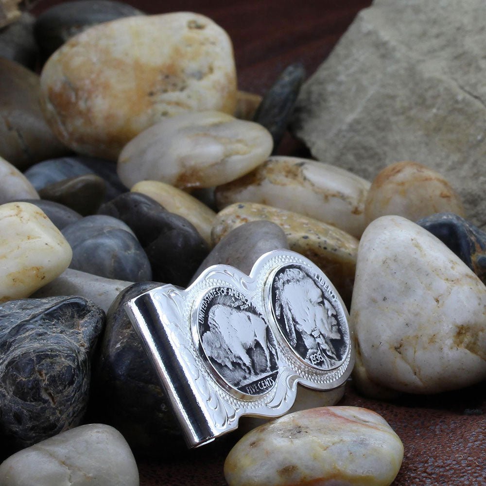 A silver money clip featuring engraved western filigree and two replica buffalo nickel coins.