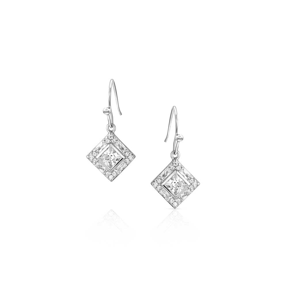 A pair of silver drop earrings featuring a diamond-shaped crystal center surrounded by small stones.