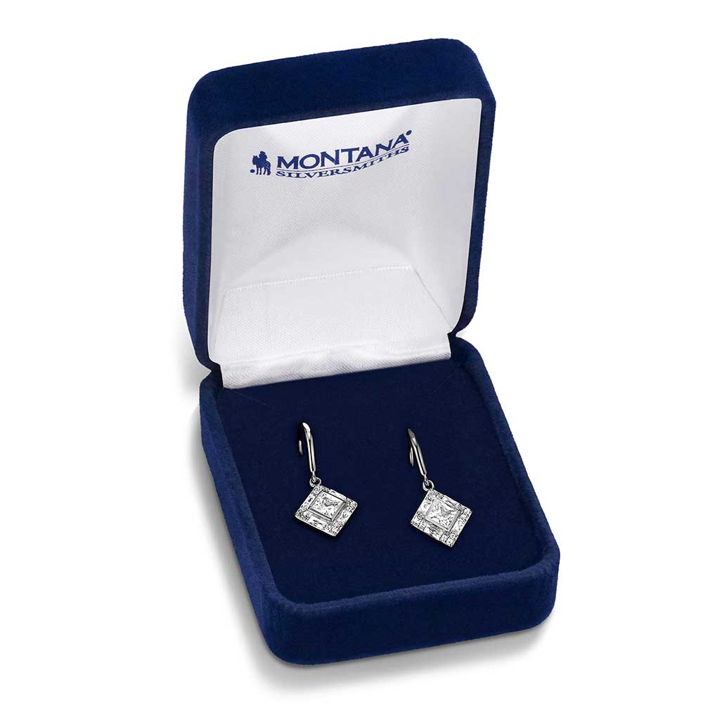 A pair of diamond-shaped crystal drop earrings in a blue Montana Silversmiths display box.