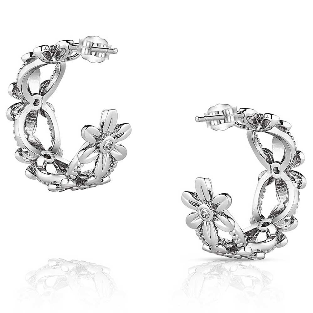 A pair of silver-tone hoop earrings featuring a floral daisy design with cubic zirconia centers.