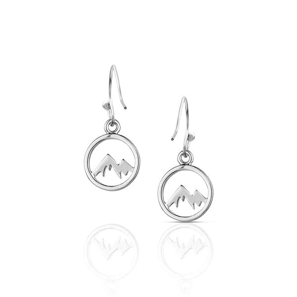 A pair of silver-tone earrings featuring a mountain range silhouette inside a circular frame.