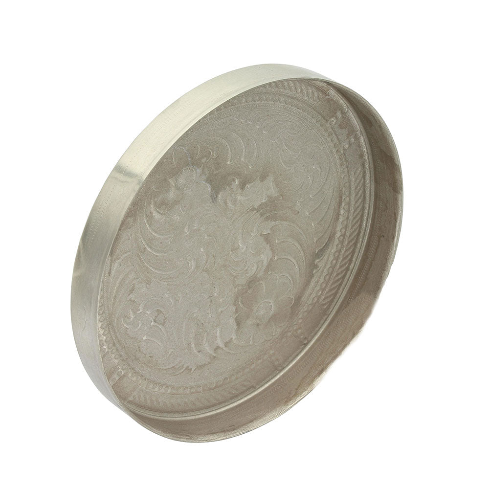 A round German silver snuff lid featuring intricate engraved scrollwork and a smooth rim.