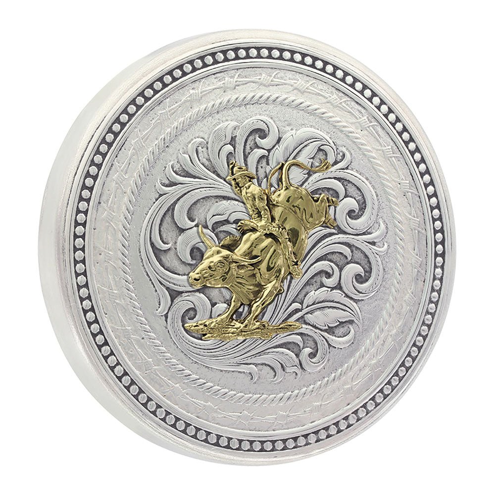 A round silver snuff lid featuring a gold bull rider figure surrounded by engraved scrollwork.