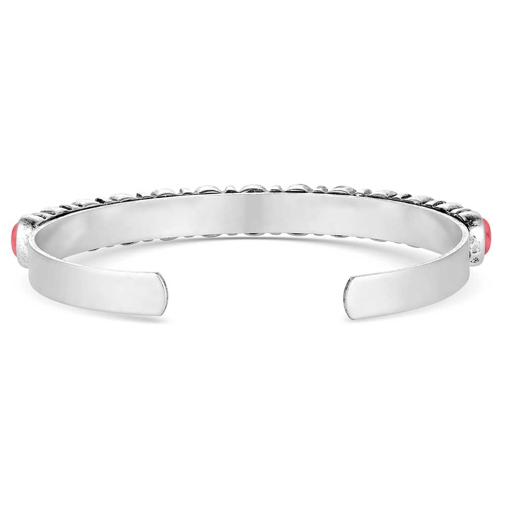 A silver tone cuff bracelet featuring alternating red and white oval stones with western detailing.