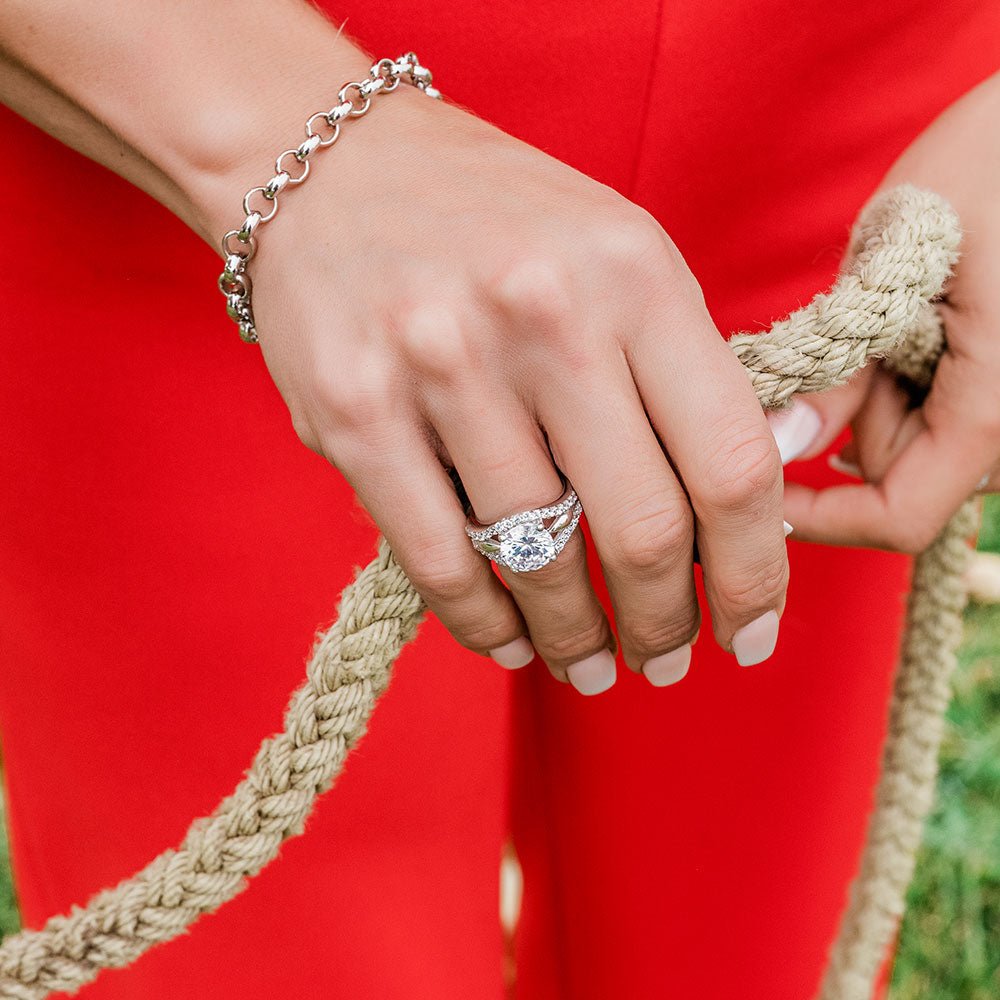 A sterling silver ring with a large round cubic zirconia center stone and split pavé bands.