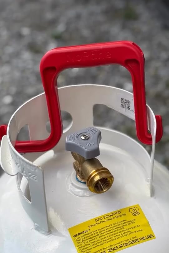 A red plastic NoPane handle attached to the top collar of a white propane tank.