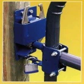 A blue two-way gate latch secured to a wooden post and a round metal gate with a padlock.