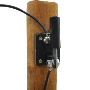 A black knife-style power cut-off switch mounted on a wooden post with two connected wires.