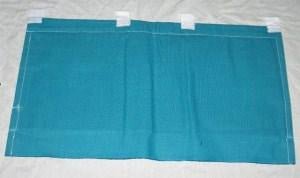 A rectangular blue canvas cattle dust bag with white hanging tabs along the top edge.