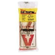 A Victor wooden snap rat trap with a metal pedal, packaged in a clear plastic bag.