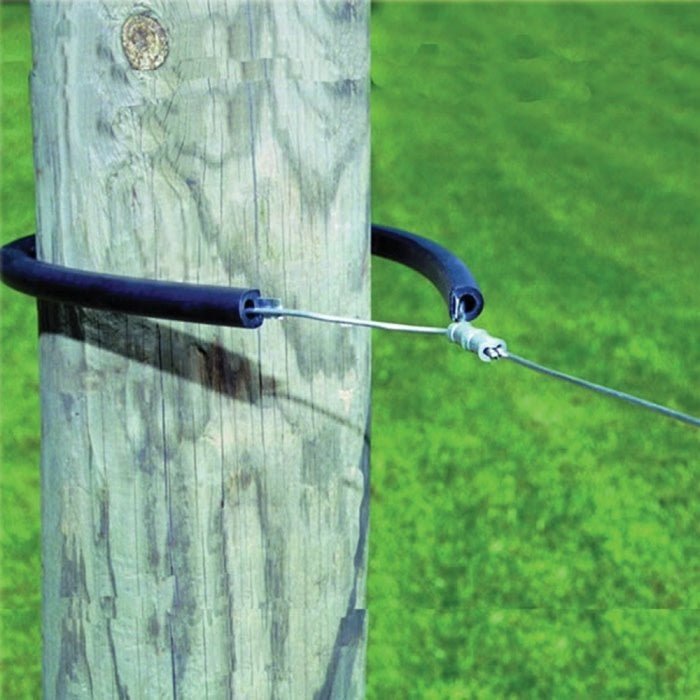A black wrap-around electric fence insulator secured around a wooden post with a wire attached.